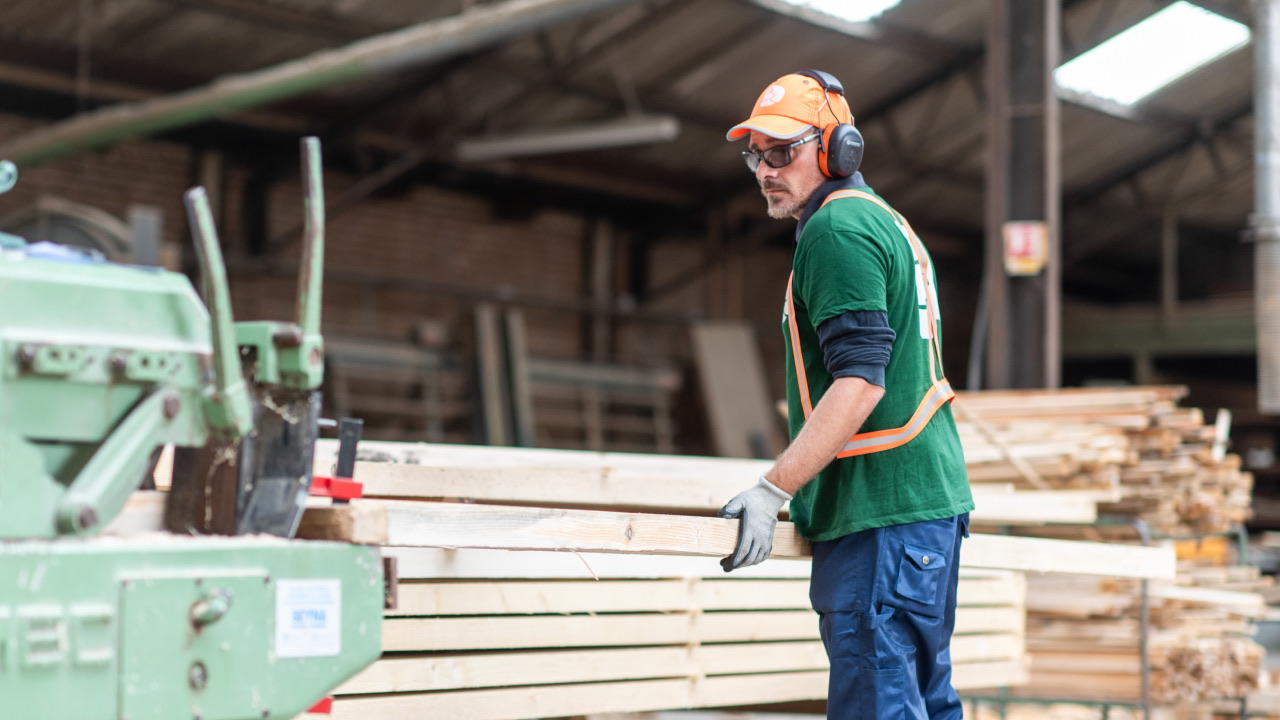 Employé de Denoyelle scierie en train de couper une planche de bois