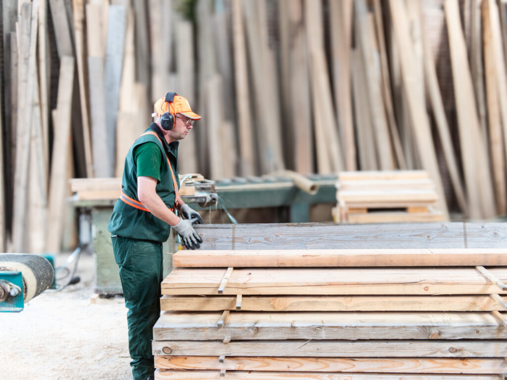 Employé de Denoyelle scierie en train de ranger du bois traité.