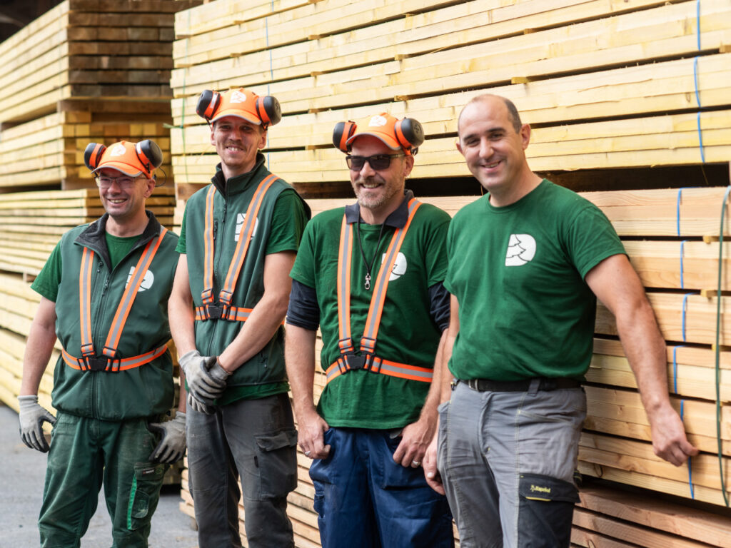 L'équipe de Denoyelle Scierie au complet en extérieur devant le stock de bois